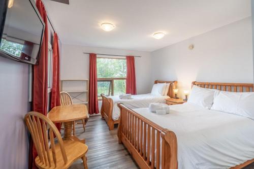 a bedroom with two beds and a table and chairs at Aurora Bayside Inn in Yellowknife