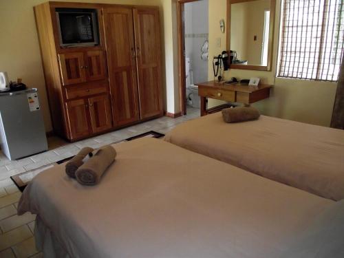 a room with two beds and a television in it at Jock-Sabie Lodge in Sabie