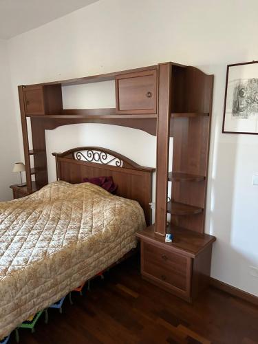 a bedroom with a wooden bed and a book shelf at Da Lucio in Montecavolo