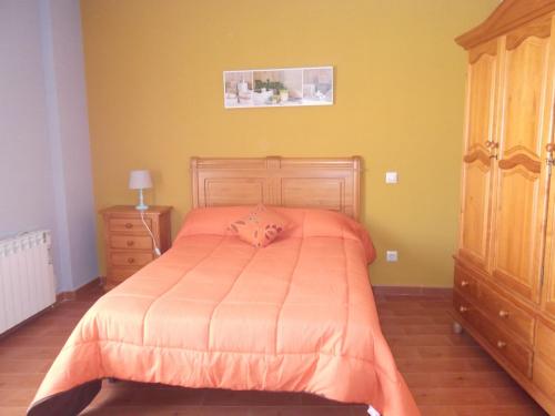 1 dormitorio con 1 cama con manta naranja en Apartamento Prado, en La Solana