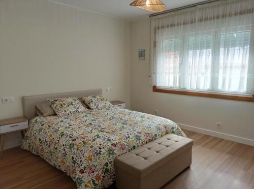 ein Schlafzimmer mit einem Bett und einer Couch darin in der Unterkunft Casa Playa Meira in Moaña