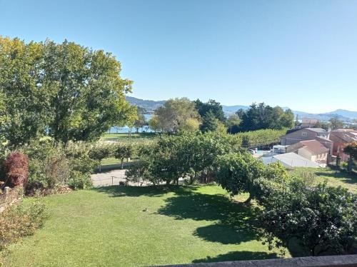 a view of a yard with trees and grass at Casa Playa Meira in Moaña