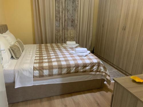 a bedroom with a bed with two towels on it at DEI Stay Apartament Tirana in Tirane