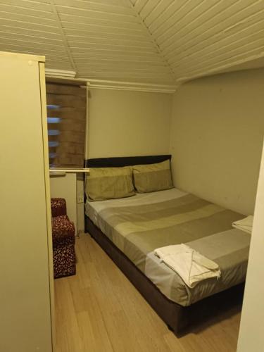 Un pequeño dormitorio con una cama y una silla. en Suite Hotel, en Estambul