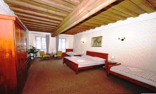 a bedroom with two beds and chairs in a room at Mini Apart Hotel Abraka in Český Krumlov