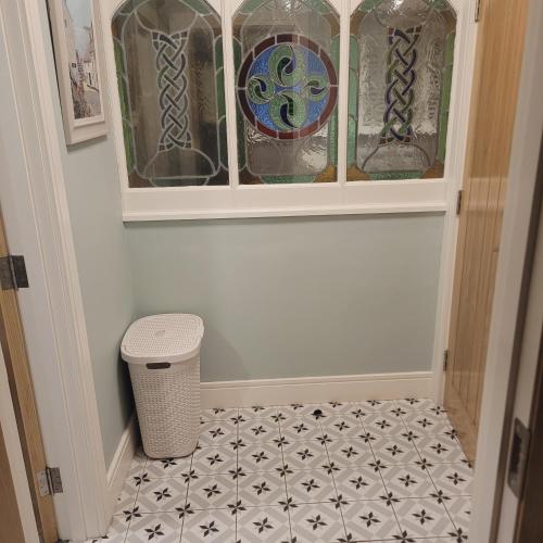 a hallway with a cabinet with stained glass at Roundstone Retreats Quayside luxury apt in Roundstone