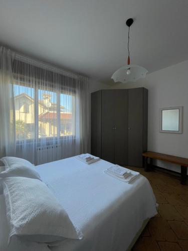 a bedroom with a large white bed and a window at Casa Vacanze Ilenia in Marina di Montemarciano