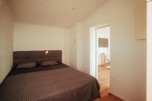 a bedroom with a bed in a white room at SkyView Dežno in Makole