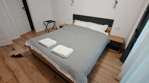 ein Schlafzimmer mit einem Bett mit zwei Handtüchern darauf in der Unterkunft Arini Urban Residence in Şelimbăr