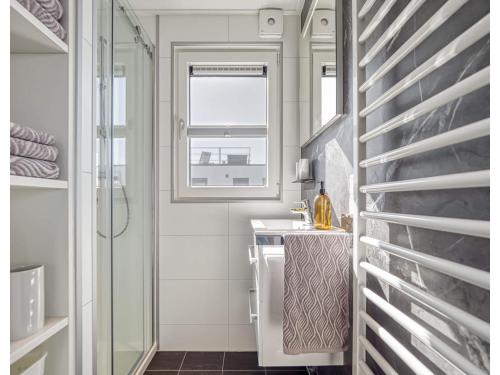 a small bathroom with a sink and a window at Bright Base with Coastal Access in Ribnitz-Damgarten