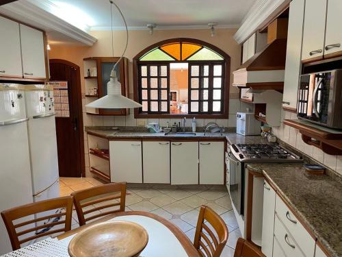 a kitchen with a table and chairs and a window at Casa em São Sebastião refúgio do pontal in São Sebastião