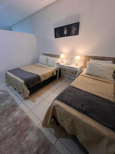 ein Schlafzimmer mit zwei Betten und einem Schreibtisch mit zwei Lampen in der Unterkunft Regency Loft 02 in Petrolina