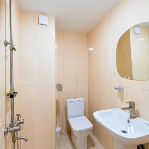 a bathroom with a toilet and a sink and a mirror at Hotel Serenity in Tbilisi City