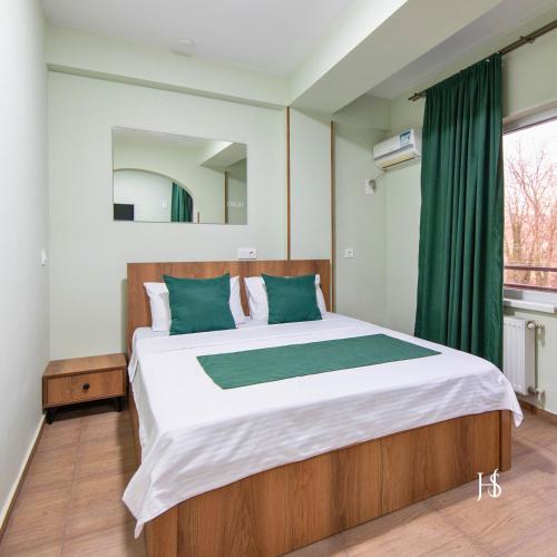 a bedroom with a large bed and a window at Hotel Serenity in Tbilisi City