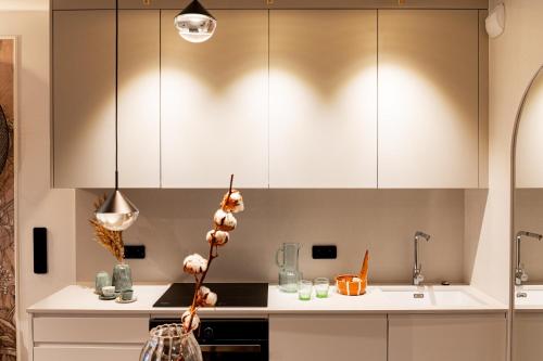 a kitchen with white cabinets and a sink at Scala Apartments by Blue Mandarin in Gdańsk