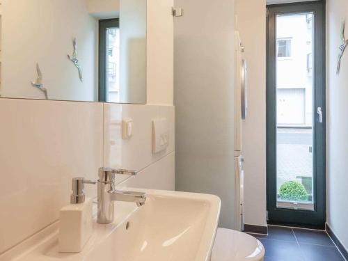 a bathroom with a sink and a toilet and a mirror at Freya - with breathtaking sea views in Sassnitz
