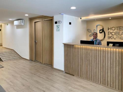 a woman is standing at a hotel reception counter at Hotel Poblado Boutique in Medellín