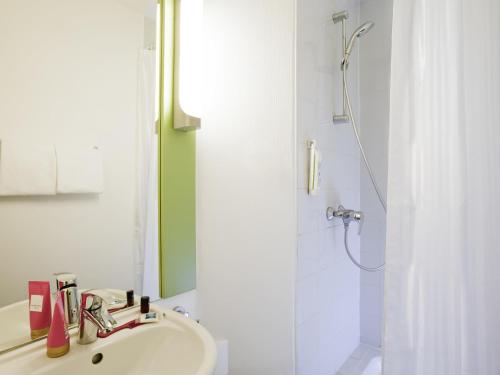 a bathroom with a sink and a shower at ibis budget Pontault Combault RN4 Marne La Vallée in Pontault-Combault
