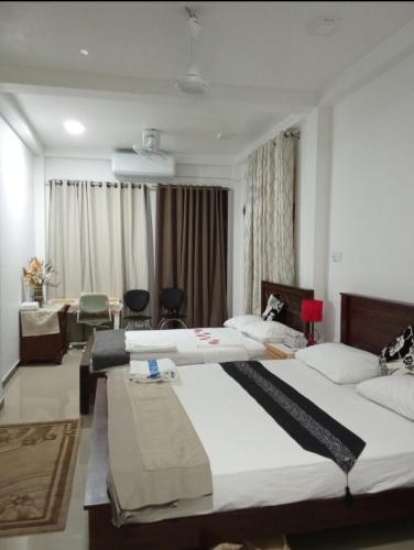 une chambre d'hôtel avec deux lits et un bureau dans l'établissement Rian Rest, à Gangodawila