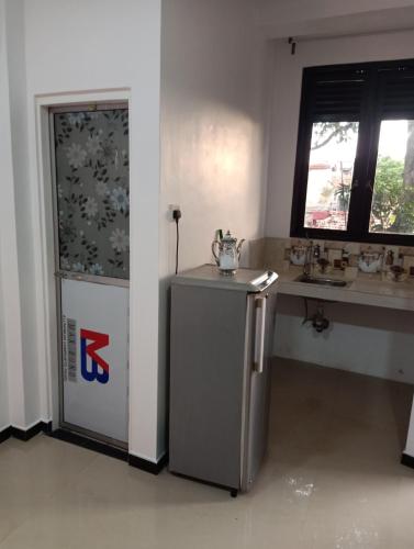 une cuisine avec un petit réfrigérateur à côté d'une fenêtre dans l'établissement Rian Rest, à Gangodawila