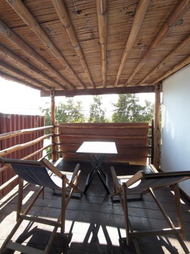 a patio with two chairs and a table on a deck at Máncora Hostel Restocafebar in Máncora