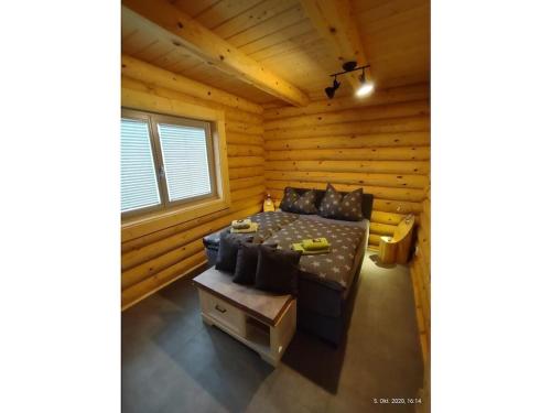 Cette cabane en rondins comprend un lit et une table. dans l'établissement Holiday home in Rieden with swimming pool, à Rieden