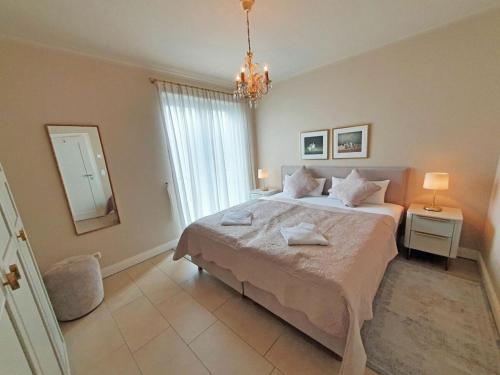a bedroom with a large bed and a chandelier at One-bedroom apartment in Sassnitz