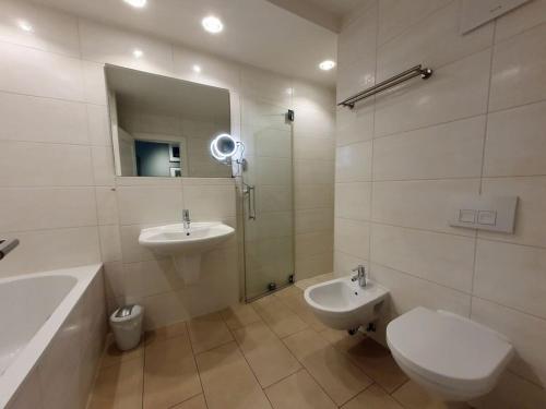 a bathroom with a sink and a toilet and a mirror at One-bedroom apartment in Sassnitz
