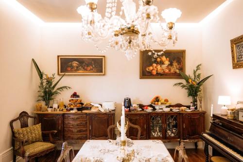 a dining room with a table and a chandelier at Quinta das Luzes by Casa dos Sequeiras in Vila Nova de Gaia