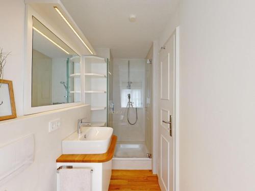 ein weißes Badezimmer mit Waschbecken und Dusche in der Unterkunft Holiday apartment with 2 bedrooms in Oldsum