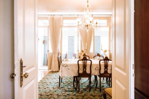 a dining room with a table with chairs and a chandelier at Quinta das Luzes by Casa dos Sequeiras in Vila Nova de Gaia