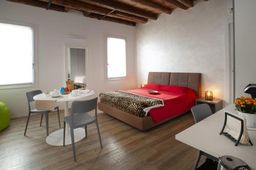 een slaapkamer met een bed, een tafel en stoelen bij Ca' dell'Angelo in Chioggia