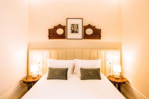 a bedroom with a white bed with two night stands at Quinta das Luzes by Casa dos Sequeiras in Vila Nova de Gaia