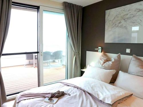 une chambre avec un grand lit et un balcon dans l'établissement Bernstein Resort, à Dorf Körkwitz