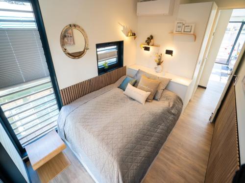 a small bed in a room with a large window at Schönes Hausboot in Höxter in Höxter