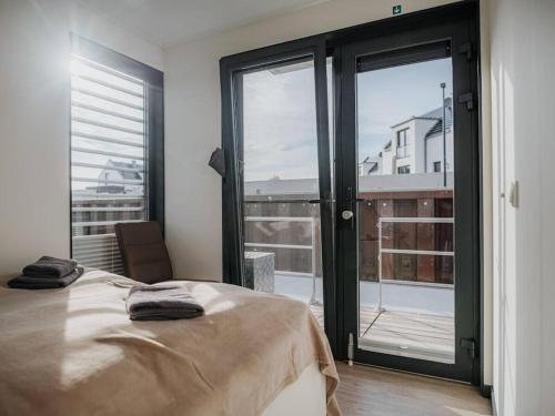 a bedroom with a bed and a large window at Peenemünde Resort in Peenemünde