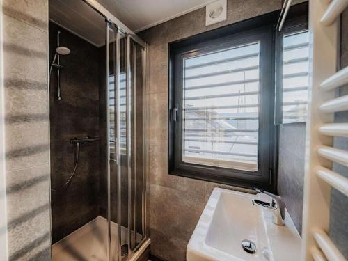 a bathroom with a shower and a sink and a window at Peenemünde Resort in Peenemünde