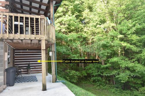 a porch with a wooden deck with a yellow rectangle on it at Laurel Lake Cabins in Corbin