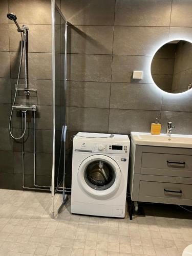a washing machine in a bathroom with a sink at Vaaranhuoneistot in Syöte