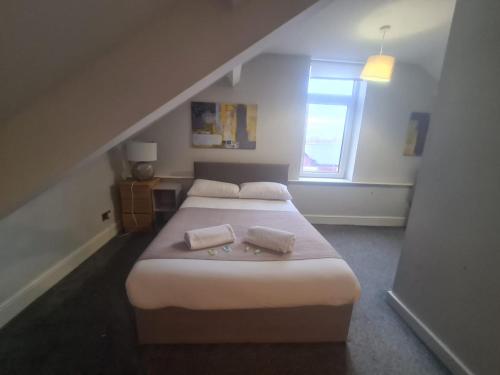 een slaapkamer met twee bedden en een raam bij Coastal town properties in Jarrow