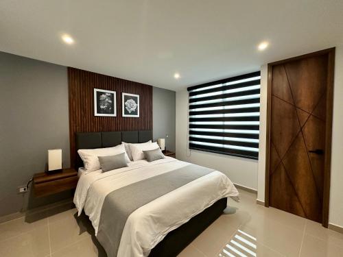 Un dormitorio con una cama grande y una ventana grande en Rooca Urban, en Medellín