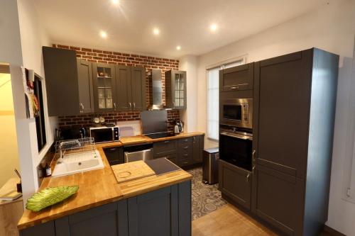 a kitchen with black cabinets and a counter top at Spacious house with garden, 15 minutes from Paris in Houilles