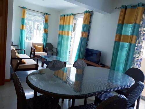 a living room with a glass table and chairs at Beachfront apartment-perfect sea escape! in Flic-en-Flac