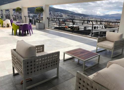 a patio with chairs and tables on a roof at Habitación en Quito in Quito