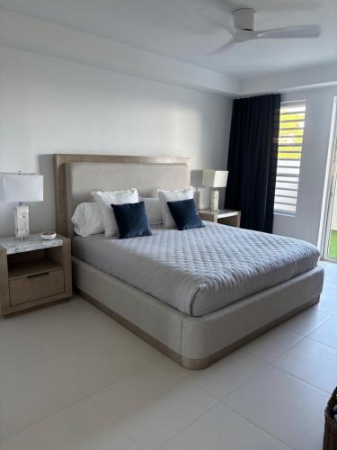a bedroom with a large bed with blue pillows at Indigo Escape in Koolbaai