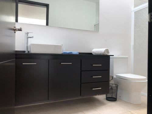 a bathroom with a sink and a toilet at House in Private Residential Development Globo-Outlets-Airport in León