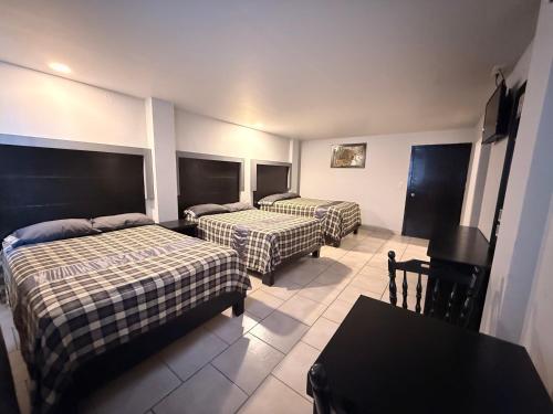 a hotel room with two beds and a table at Hotel Nieto Express in Matamoros