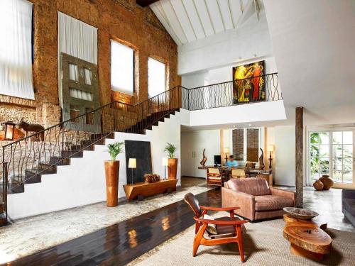 a living room with a staircase and a couch at Santa Teresa Hotel Rio de Janeiro - MGallery Collection in Rio de Janeiro