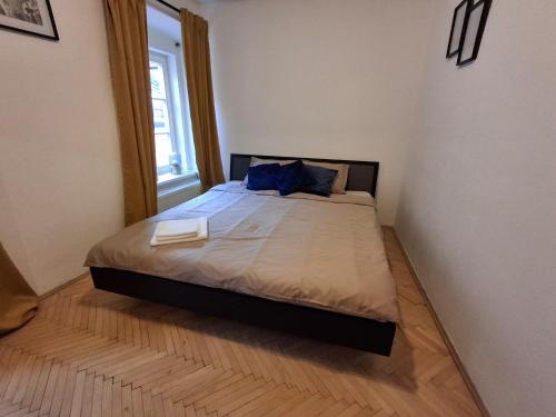 a bedroom with a bed with blue pillows and a window at Central Modern Studio - wifi, coffee in Bratislava