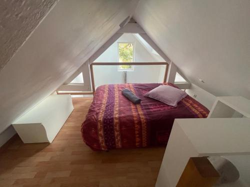a bedroom with a bed in the middle of a attic at Les Dunes de Longchamp in Saint-Lunaire
